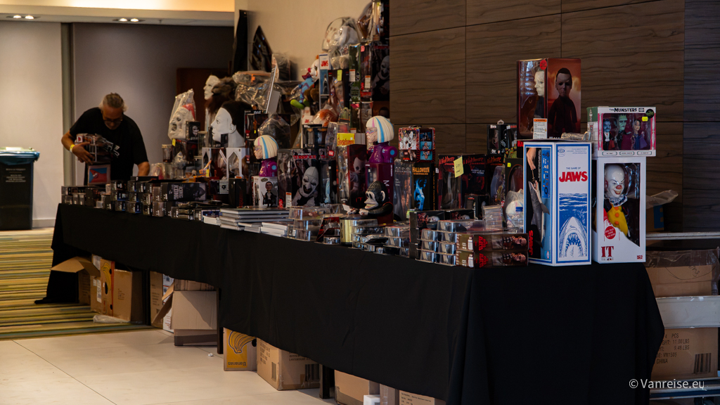 Händlerstand mit verpackten Horrorfiguren, Masken und weiteren Fanartikeln