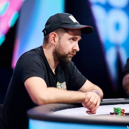 Adam Wolke sitzt mit schwarzer Kappe an einem Pokertisch