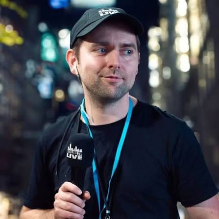 Adam Wolke mit schwarzer Kappe und SkylineTV-Mikrofon