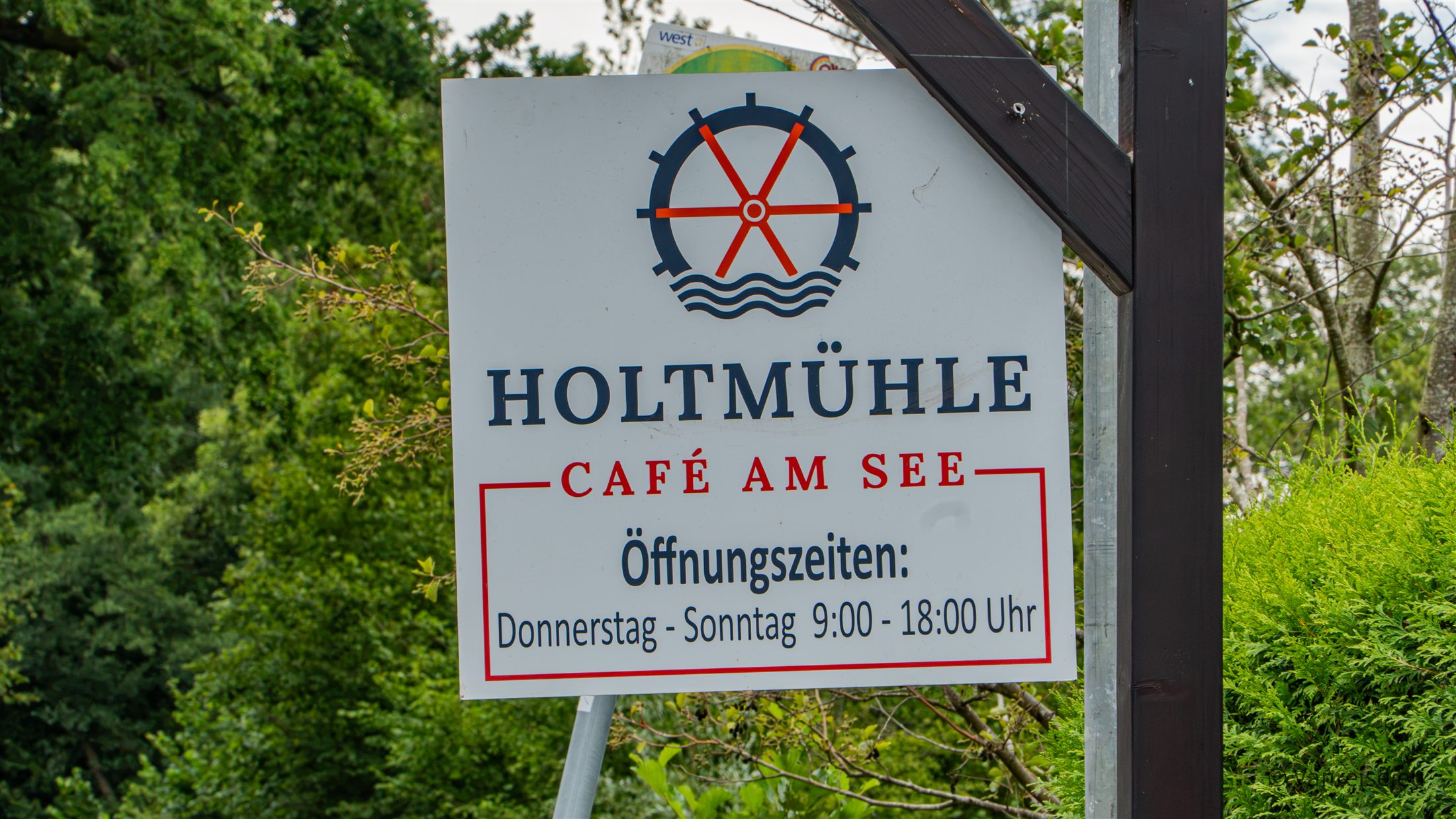 Schild der Holtmühle Café am See mit Öffnungszeiten