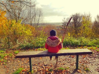 Kind auf einer Bank mit dem Blick in die Ferne